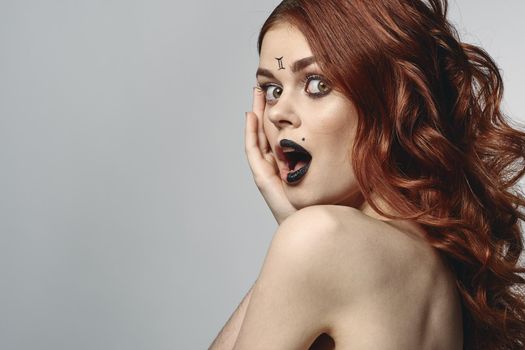 red-haired woman with bare shoulders bright makeup base zodiac sign horoscope. High quality photo