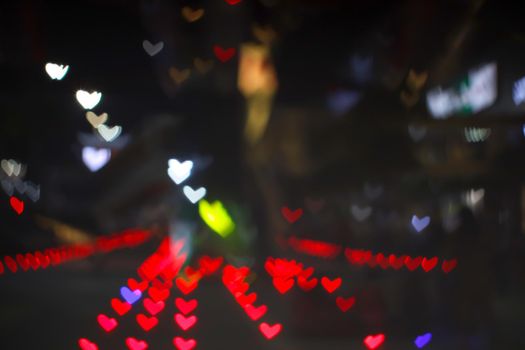 red bokeh and blur heart shape love valentine colorful night light on floor at shopping mall