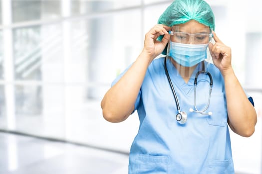 Asian doctor wearing face shield and PPE suit new normal to check patient protect safety infection Covid-19 Coronavirus outbreak at quarantine nursing hospital ward.