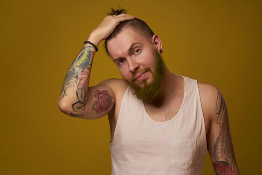 macho man in white t-shirt tattoos on his arms posing isolated background. High quality photo