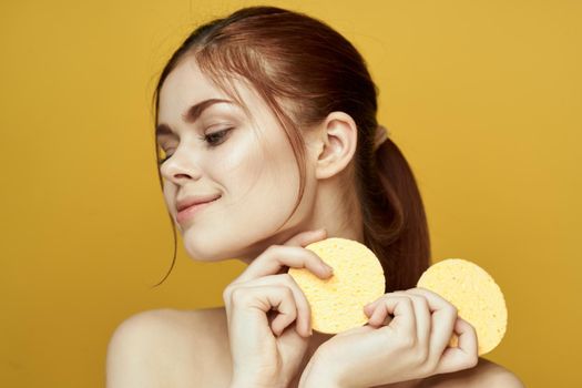 pretty woman with sponges in her hands bare shoulders clean skin hygiene. High quality photo
