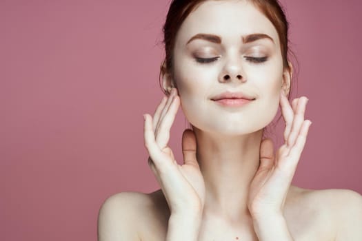 woman with bare shoulders charm cosmetics pink background posing. High quality photo