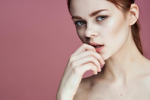 woman with bare shoulders charm cosmetics pink background posing. High quality photo