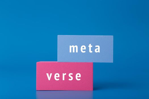 Metaverse modern minimal concept in dark elegant blue colors. Written metaverse word on blue and pink rectangles against blue background. Innovational future computer technologies. 