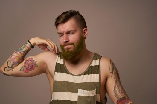 handsome man with tattoos on his arms fashionable hairstyle emotions. High quality photo