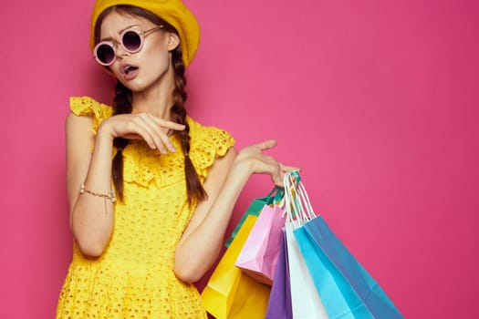 cheerful woman with multicolored bags posing pink background. High quality photo