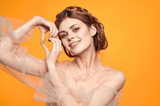 pretty woman with fashionable hairstyle in dress posing yellow background. High quality photo