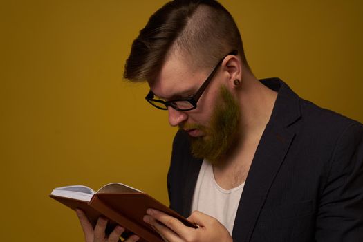 bearded man in a black jacket with a book in his hands education. High quality photo