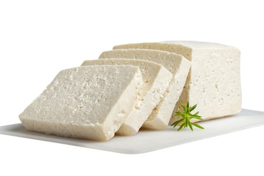 White cheese cut into several pieces on a white surface and white background