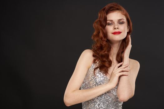 elegant woman in silver dress beautiful hairstyle posing dark background. High quality photo