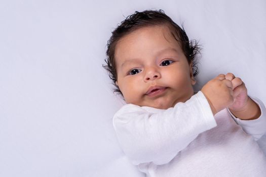 Infant lying on his back with his hands up