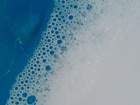 Close-up picture of their pattern in the bubbles of bath foam in blue water