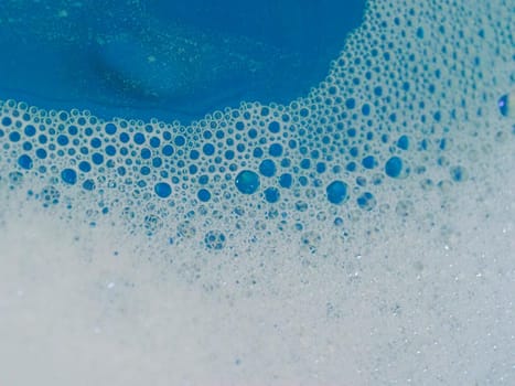 Close-up picture of their pattern in the bubbles of bath foam in blue water