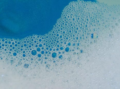 Close-up picture of their pattern in the bubbles of bath foam in blue water