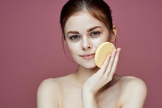 woman with bare shoulders sponge in hands clean skin hygiene. High quality photo
