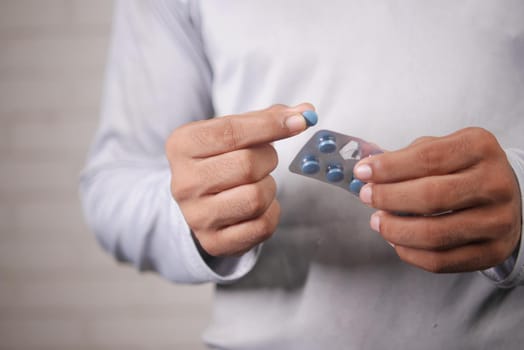 Close up of man holding blister packs