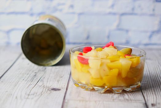 Open can of fruit cocktail on table