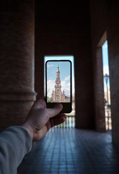 Man hand take a photo with smart phone to hte Square of Spain (Plaza de Espana) Seville