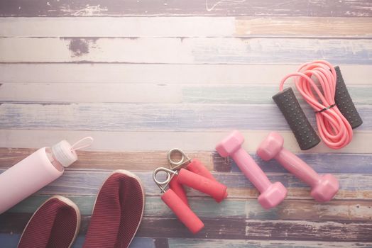 pink color dumbbell, shoe and headphone on table .