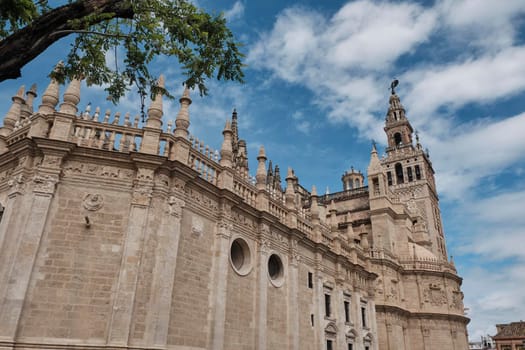 view Cathedral of Saint Mary of the See (Seville Cathedral) in Seville, Andalusia, Spain in a sunny and cloudy day