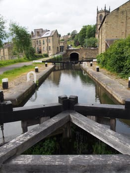 the wooden lock gates on the aire and calder navigation canal with a view of the west yorkshire town of sowerby bridge