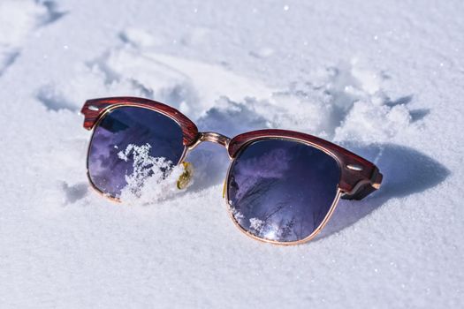 Forgotten or lost by someone sunglasses on white snow in winter