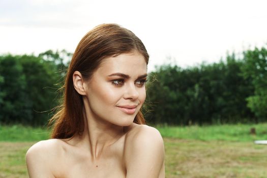 pretty woman in a field outdoors bare shoulders clear skin cropped view. High quality photo