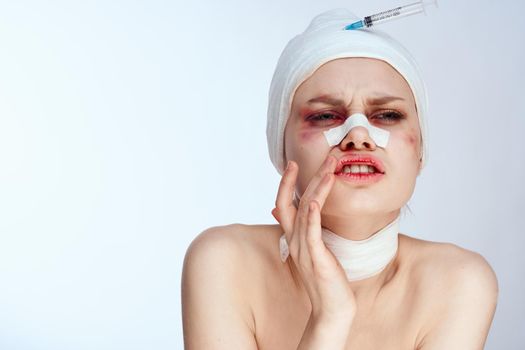 emotional woman bandaged face the syringe sticks out in the head studio lifestyle. High quality photo