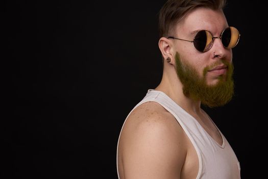 bearded man in white t-shirt with tattoos on his arms posing bully. High quality photo