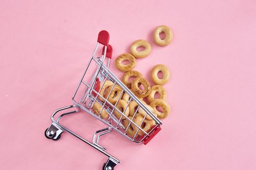 small shopping carts supermarket shopping pink background. High quality photo