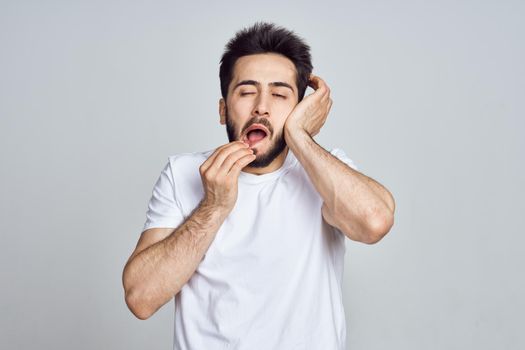 bearded man in white t-shirt posing gesturing with his hands. High quality photo