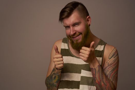 fashionable man with tattoos on his arms stylish hairstyle self-confidence studio. High quality photo