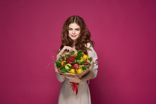 portrait of a woman fun posing fruit bouquet vitamins pink background. High quality photo