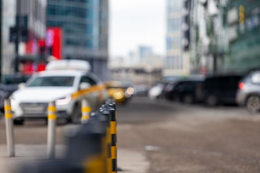 row of parking bollards on the street of the metropolis. black and yellow car barriers