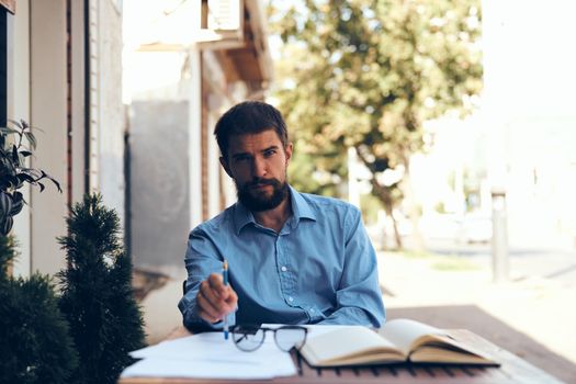 business man with papers in a summer cafe work communication. High quality photo