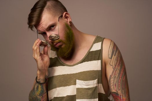 bearded man in striped t-shirt glasses tattoo on his arms fashion. High quality photo