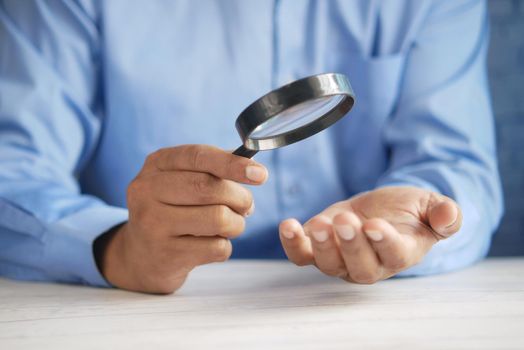 young men discovering his luck with magnifying glass .