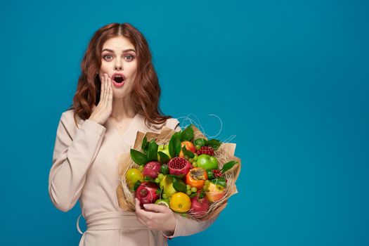 pretty woman smile posing fruit bouquet vitamins blue background. High quality photo