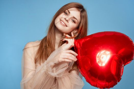 portrait of a woman red heart in the hands of the balloon blue background. High quality photo