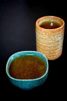 Tea in ceramic cup on black background