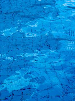 Reflection of sky on the moving water surface in the pool