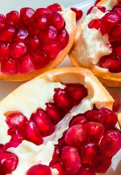 Top view closeup image of red pomegranate seeds on pomegranate seeds pile present a detail of pomegranate seeds texture, fruit background, red background