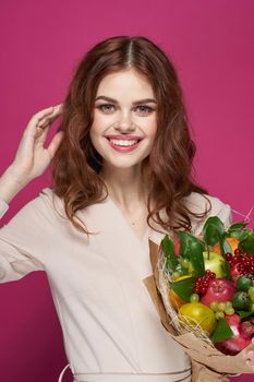 beautiful woman smile posing fresh fruits bouquet emotions pink background. High quality photo