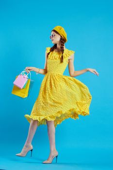 smiling woman with multicolored bags posing blue background. High quality photo