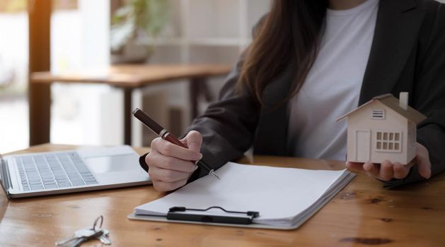 real estate realtor working in the office, reviewing rental contract on papers. Property consultant working in a modern office.