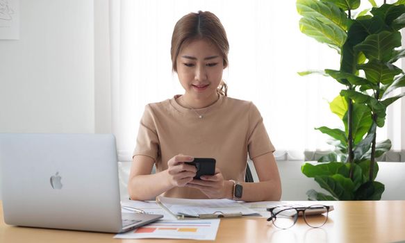 Close up Businesswoman using calculator and laptop for calaulating finance, tax, accounting, statistics and analytic research concept