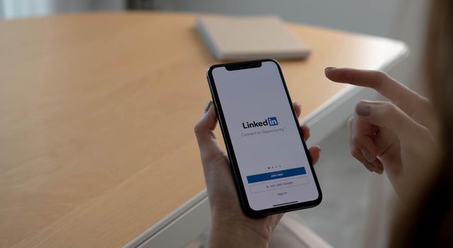 CHIANG MAI, THAILAND, OCT 12, 2021 : A women holds Apple iPhone Xs with LinkedIn application on the screen.LinkedIn is a photo-sharing app for smartphones...