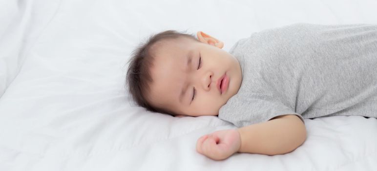 Portrait of asian little baby girl sleeping on bed in the bedroom at home, newborn napping with cozy and relax, infant innocence in bedtime, happy toddler cute, growth of child and emotion, indoors.