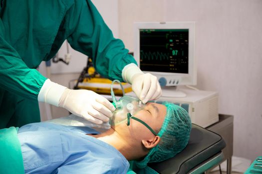 Team doctor and assistant holding oxygen mask with patient emergency in the operation room at hospital, surgeon healing and surgery, problem of breathing, instruments medical and health.