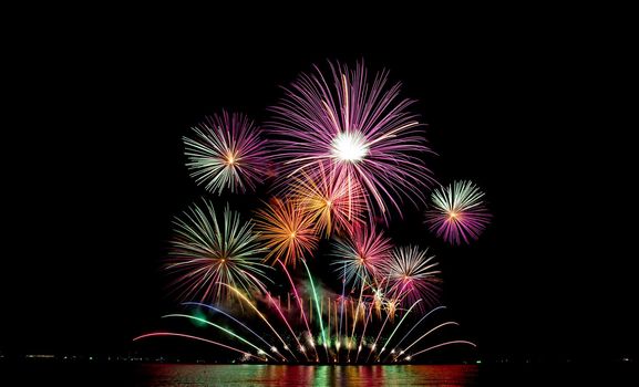 Many flashing colorful fireworks in event amazing with black background celebrate New Year, holiday and festival in night.